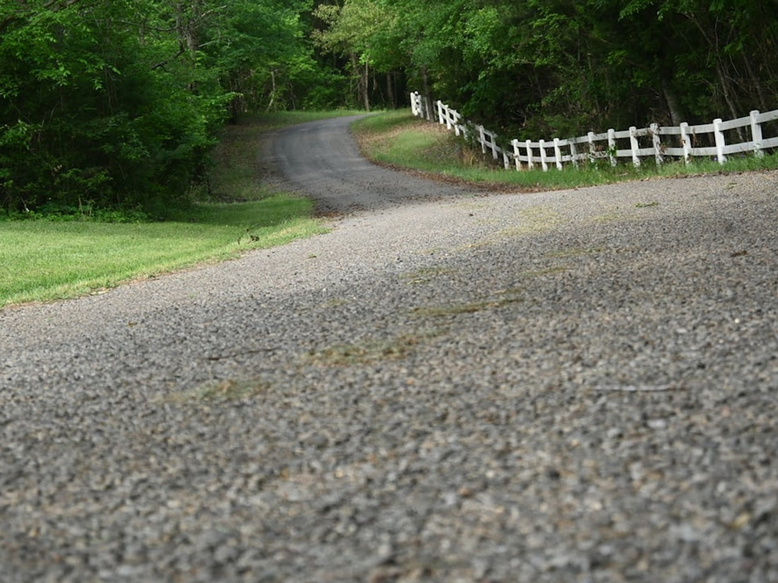 Measuring driveway gradient with a spirit level and timber board to check gravel grid suitability